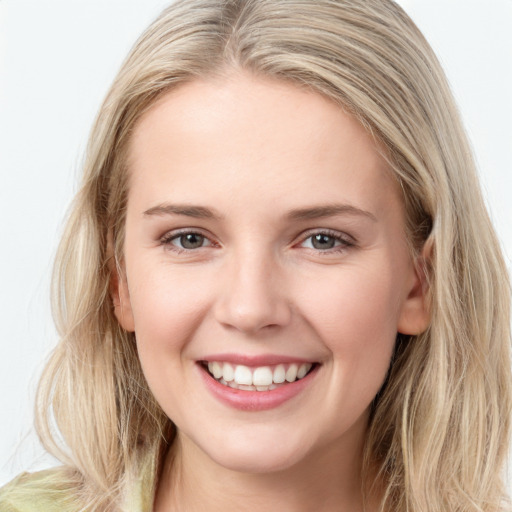 Joyful white young-adult female with long  brown hair and blue eyes