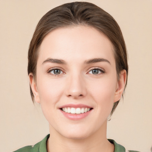 Joyful white young-adult female with medium  brown hair and green eyes