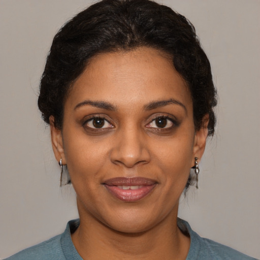 Joyful black young-adult female with short  brown hair and brown eyes