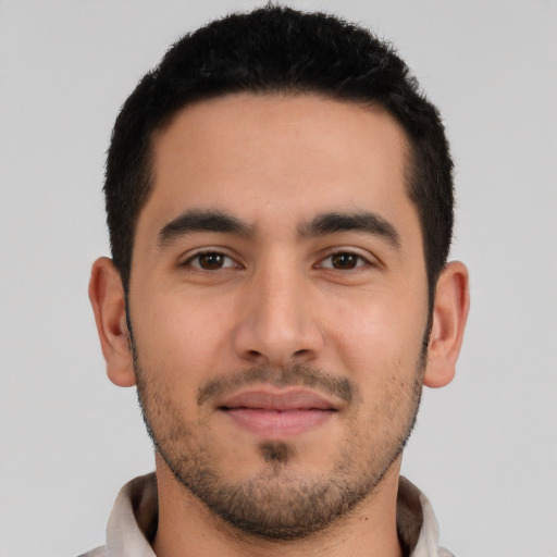 Joyful latino young-adult male with short  black hair and brown eyes