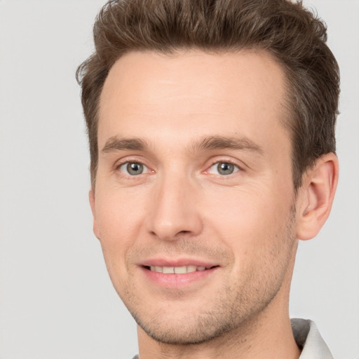 Joyful white young-adult male with short  brown hair and grey eyes