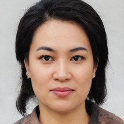 Joyful asian young-adult female with medium  black hair and brown eyes