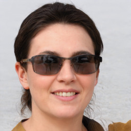 Joyful white young-adult female with medium  brown hair and blue eyes