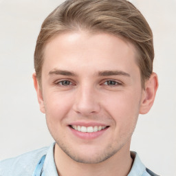 Joyful white young-adult male with short  brown hair and grey eyes