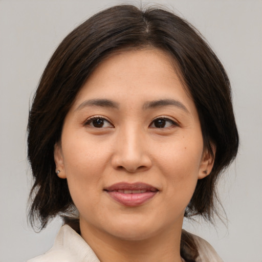 Joyful asian young-adult female with medium  brown hair and brown eyes