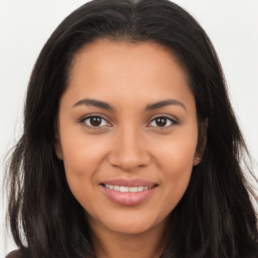 Joyful latino young-adult female with long  brown hair and brown eyes