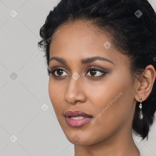 Joyful black young-adult female with long  black hair and brown eyes