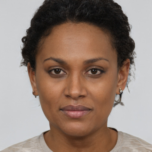 Joyful black adult female with short  brown hair and brown eyes