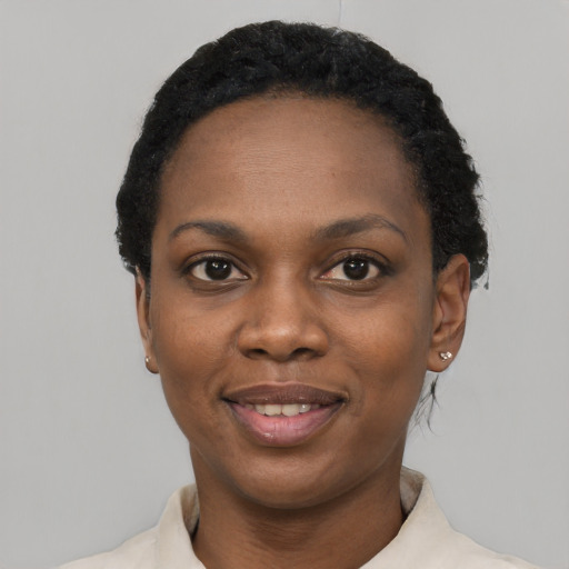 Joyful black young-adult female with short  black hair and brown eyes