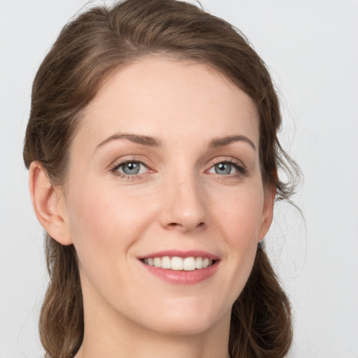 Joyful white young-adult female with medium  brown hair and grey eyes