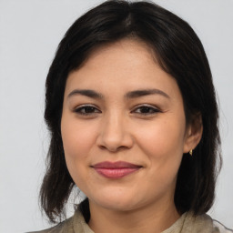 Joyful latino young-adult female with medium  brown hair and brown eyes