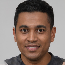 Joyful black young-adult male with short  black hair and brown eyes