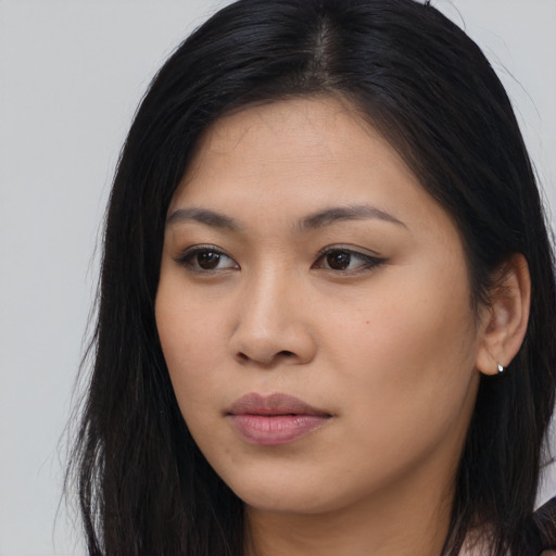 Joyful asian young-adult female with long  brown hair and brown eyes