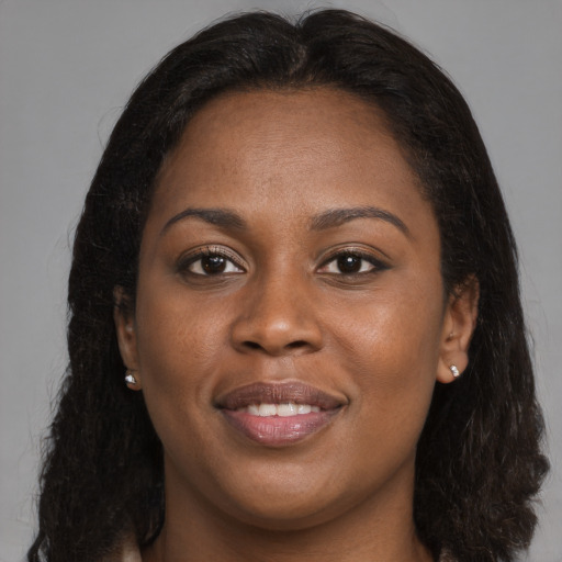 Joyful black young-adult female with long  brown hair and brown eyes