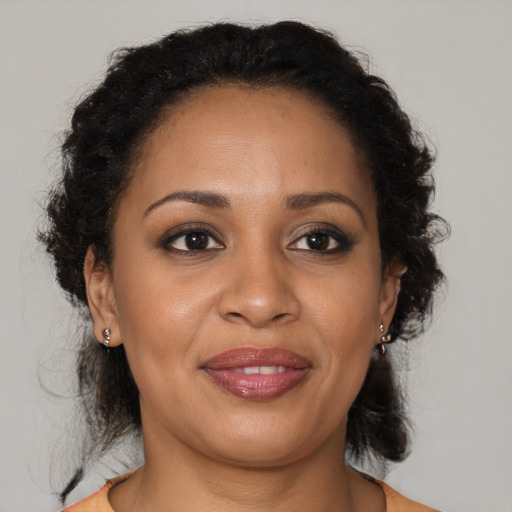 Joyful black adult female with medium  brown hair and brown eyes