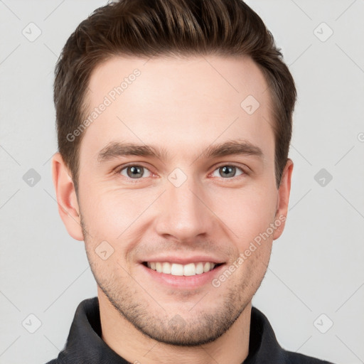 Joyful white young-adult male with short  brown hair and grey eyes