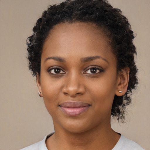 Joyful black young-adult female with short  black hair and brown eyes
