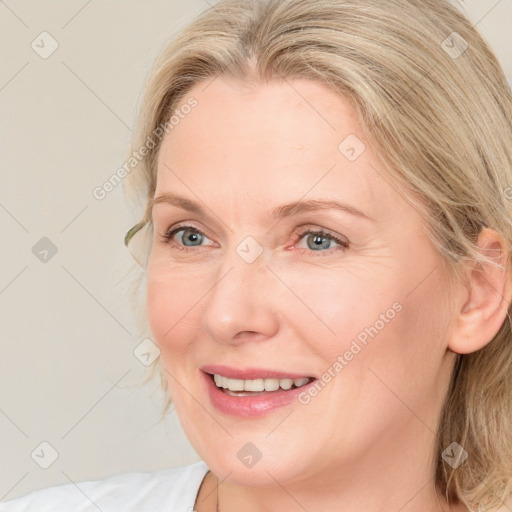 Joyful white adult female with medium  brown hair and blue eyes