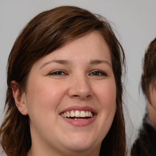 Joyful white young-adult female with medium  brown hair and brown eyes