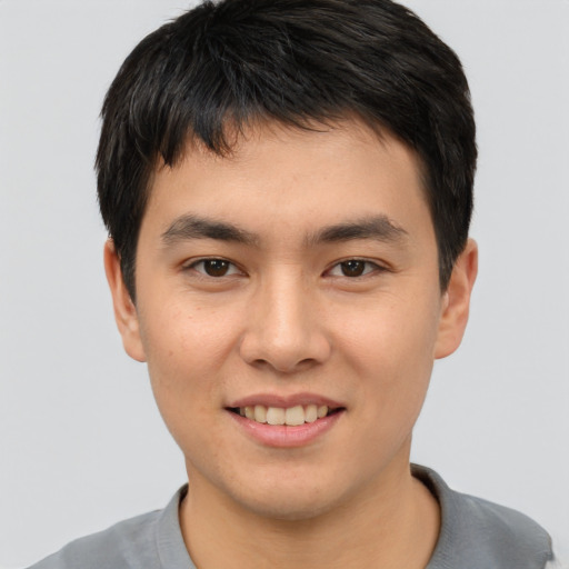 Joyful asian young-adult male with short  brown hair and brown eyes