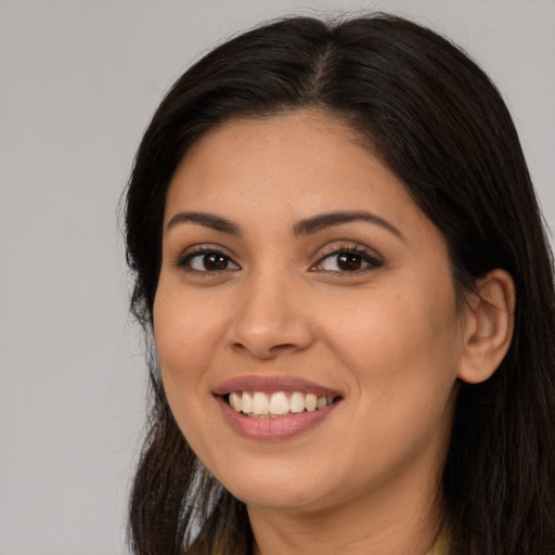 Joyful latino young-adult female with long  brown hair and brown eyes