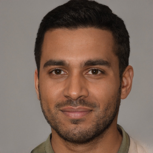 Joyful black young-adult male with short  brown hair and brown eyes