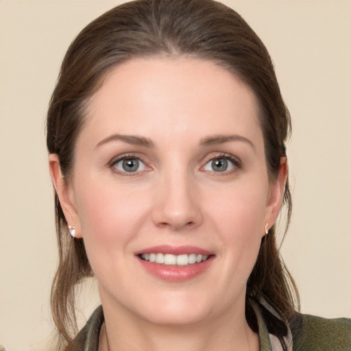 Joyful white young-adult female with long  brown hair and grey eyes