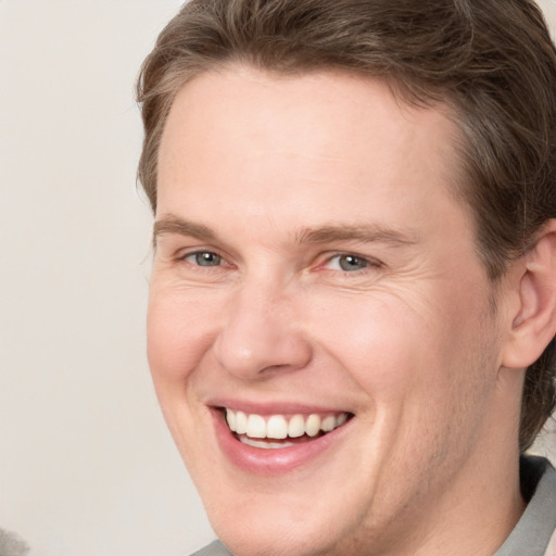 Joyful white adult male with short  brown hair and grey eyes