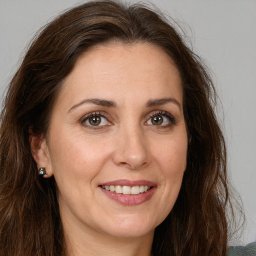 Joyful white adult female with long  brown hair and brown eyes