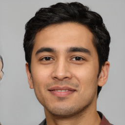 Joyful white young-adult male with short  black hair and brown eyes