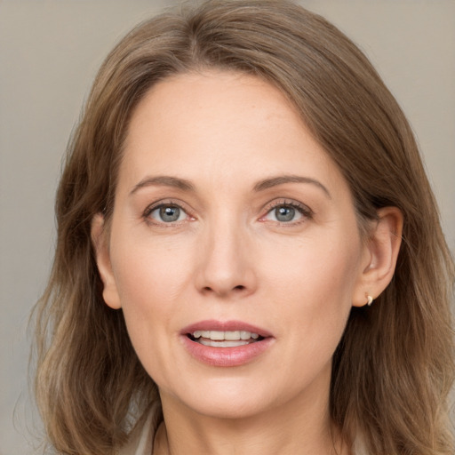 Joyful white adult female with long  brown hair and grey eyes