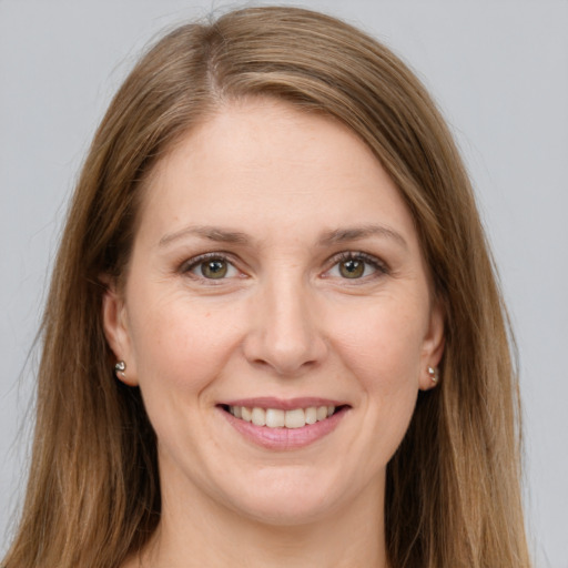 Joyful white young-adult female with long  brown hair and green eyes