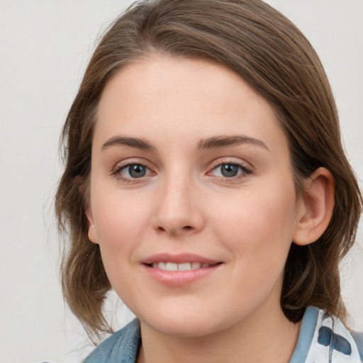 Joyful white young-adult female with medium  brown hair and blue eyes