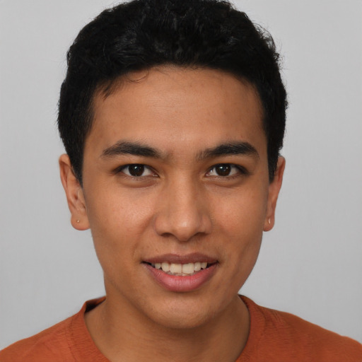 Joyful latino young-adult male with short  black hair and brown eyes