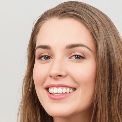 Joyful white young-adult female with long  brown hair and green eyes