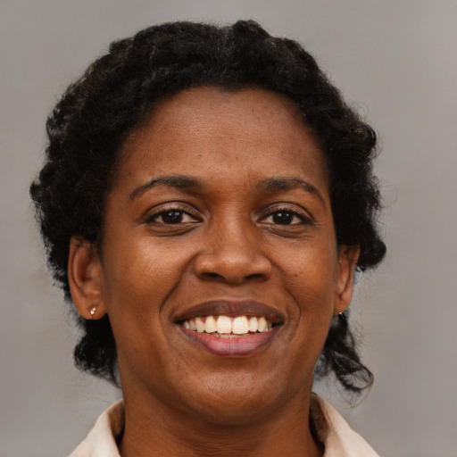 Joyful black adult female with medium  black hair and brown eyes