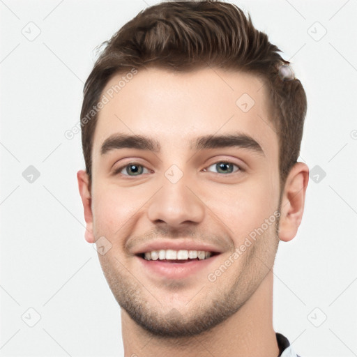 Joyful white young-adult male with short  brown hair and grey eyes