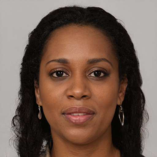 Joyful black young-adult female with long  brown hair and brown eyes