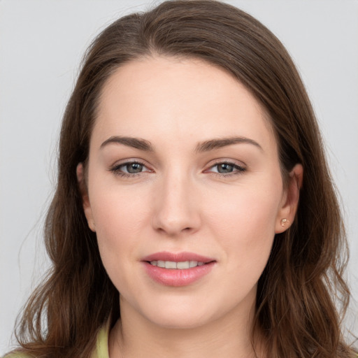 Joyful white young-adult female with long  brown hair and grey eyes