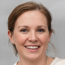 Joyful white adult female with medium  brown hair and grey eyes