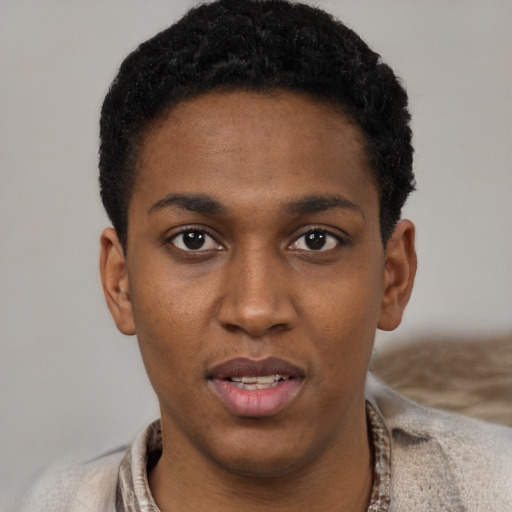 Joyful black young-adult male with short  black hair and brown eyes
