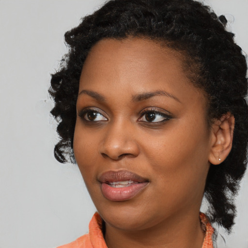 Joyful black young-adult female with medium  black hair and brown eyes