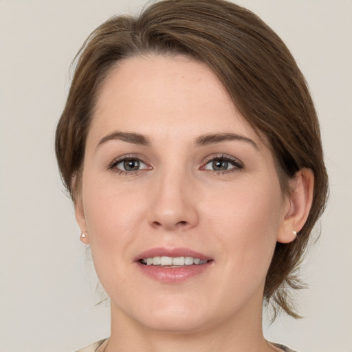 Joyful white young-adult female with medium  brown hair and grey eyes