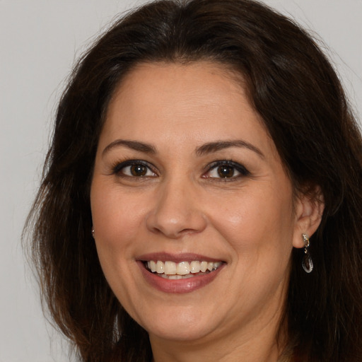 Joyful white adult female with long  brown hair and brown eyes