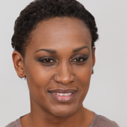 Joyful black young-adult female with short  brown hair and brown eyes