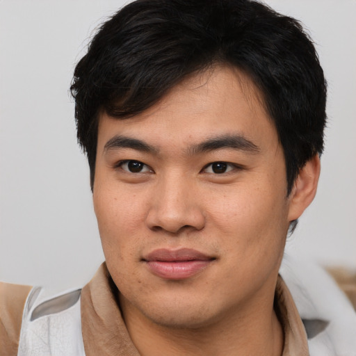 Joyful asian young-adult male with short  brown hair and brown eyes