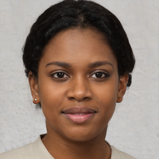 Joyful black young-adult female with short  brown hair and brown eyes