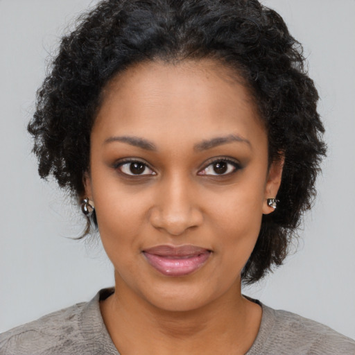 Joyful black young-adult female with short  brown hair and brown eyes