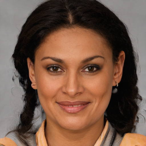 Joyful latino adult female with medium  brown hair and brown eyes