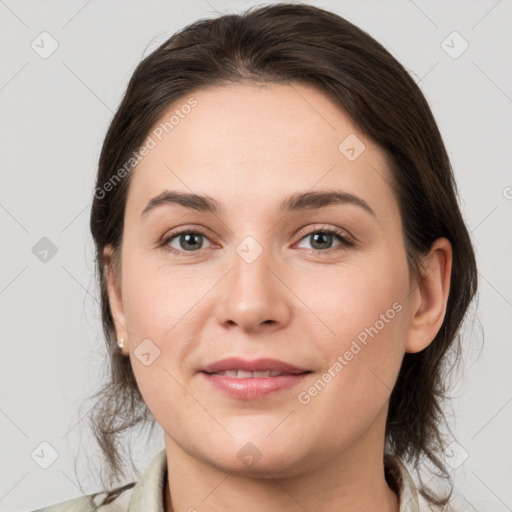 Joyful white young-adult female with medium  brown hair and grey eyes